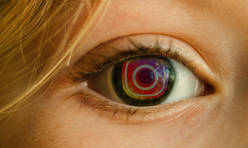 woman with instagram logo reflected in eye - technology addiction