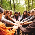 A group on a team building retreat rallying together in nature - Types of Retreats concept image