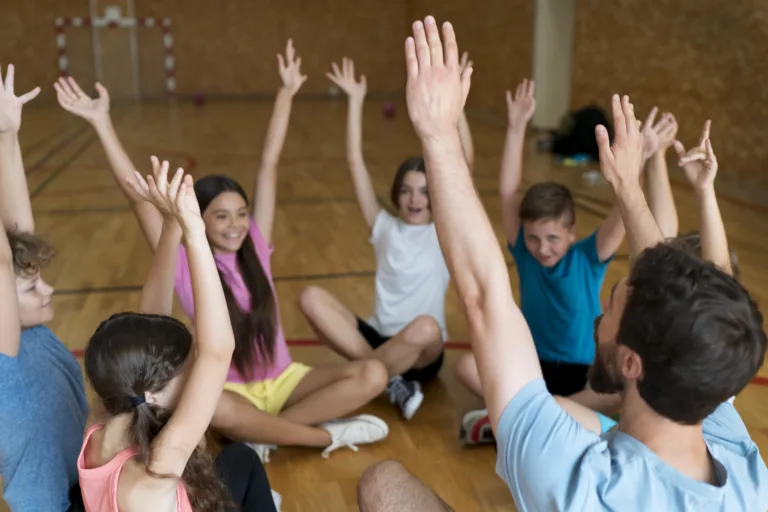 school club retreat - group of kids holding their hands up at a school club retreat concept image.